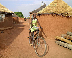 Un enfant à bicyclette dans un village